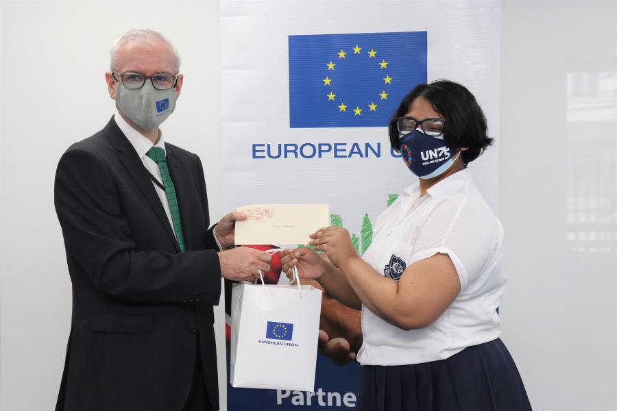 Azizah Mohammed gets her prize from the EU Ambassador