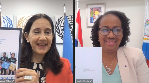 UN Resident Coordinator, Marina Walter (left), and Prime Minister of Sint Maarten, the Honourable Silveria Jacobs (right), display their signed copies of the MSDCF during a virtual signing ceremony.
